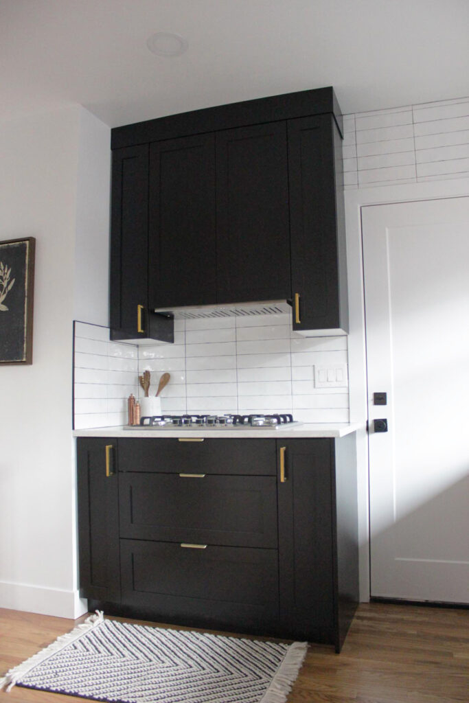 Black kitchen cabinet with gold accessories