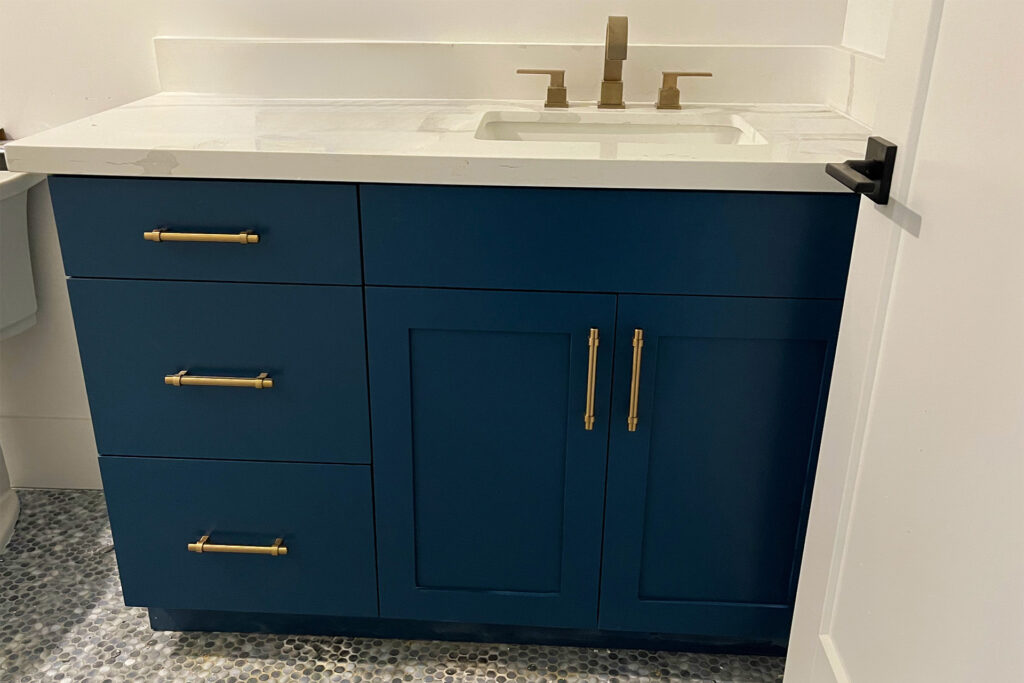 Custom blue bathroom cabinet with golden hardware