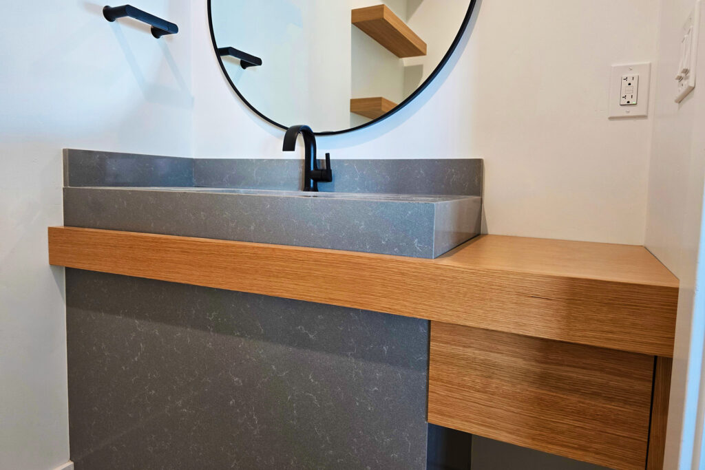 Modern commercial style bathroom sink cabinet made of stone and wood